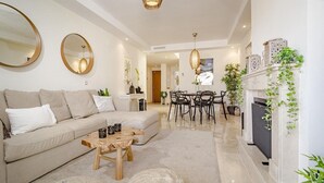 A modern living room with a sofa, coffee table, and dining area. - Ar23 - Holiday Flat, Puerto Banus by Roomservices (Marbella)