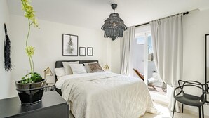 A bedroom with a bed, a desk, a chair, a hanging light fixture, and a window with curtains. - Ar23 - Holiday Flat, Puerto Banus by Roomservices (Marbella)