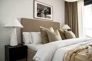 A neatly made bed with white and striped pillows, a headboard, and a framed picture above. - Lme133a- Stunning Flat Close to Beach in Estepona (Estepona)