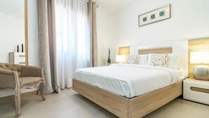A modern hotel room with a large bed, a chair, a nightstand, and a wall-mounted lamp. - Cpg- Perfect Holiday Home Close to Puerto Banus (Marbella)
