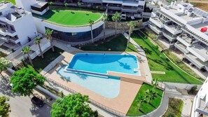 Ein Luftbild eines modernen Hotels mit Schwimmbad, mehreren Balkonen und angelegten Gr ünflächen.