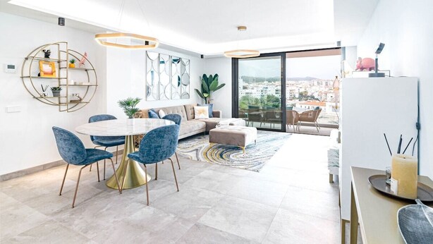 Sala moderna com área de jantar, sofá e vista para a cidade.