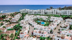 A coastal residential area with white buildings, a central swimming pool, and a view of the sea. - LVB - Casa Linda Vista by Roomservices (Marbella)
