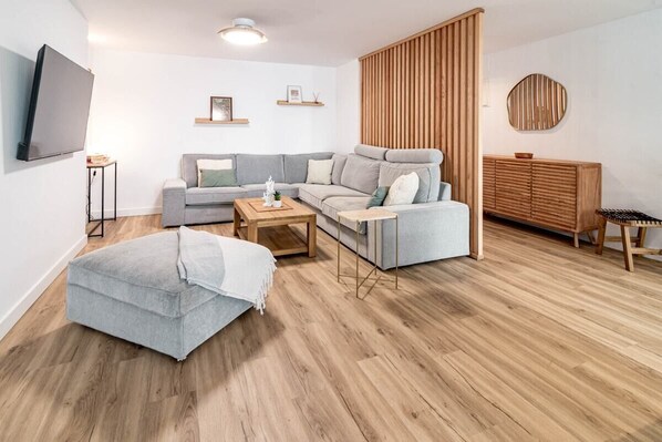 A modern living room with a grey sofa, a wooden coffee table, and a grey ottoman. - Eac3f- Modern & Light Apartment Steps From the sea (Estepona)