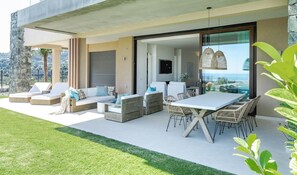 Un espace de vie extérieur comprenant une table à manger, des chaises, des canapés et un téléviseur.