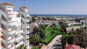 Un quartier résidentiel en bord de mer, avec des bâtiments blancs, des balcons et une vue dégagée sur la mer.