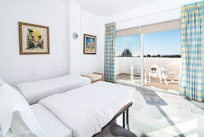 A hotel room with two beds, a balcony with a view, and two framed artworks on the wall. - Rg325 - Great 2 Bed Apt, Close to Puerto Banus (Marbella)