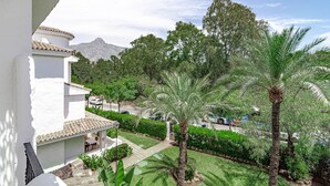 A white building with a tiled roof, a palm tree, and a mountain in the background. - Lnm530 - Great Location With Private Roof Terrace (Marbella)