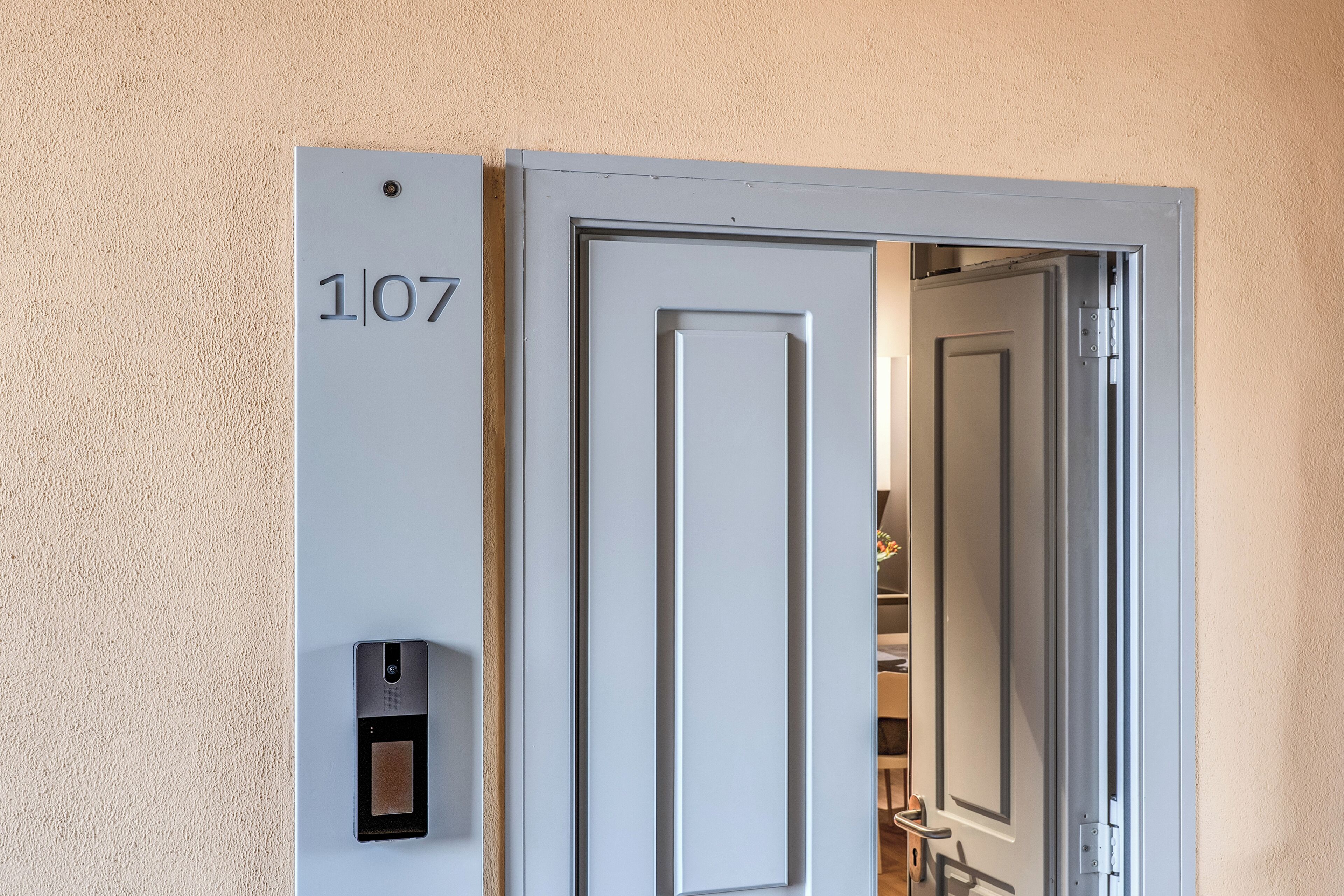 A door with a number plate '1/07' and a wall-mounted intercom.