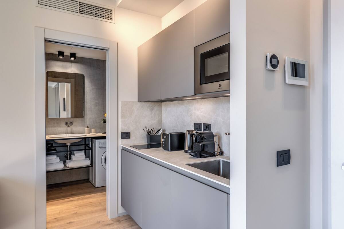 A modern kitchen with a built-in microwave, toaster, and sink.