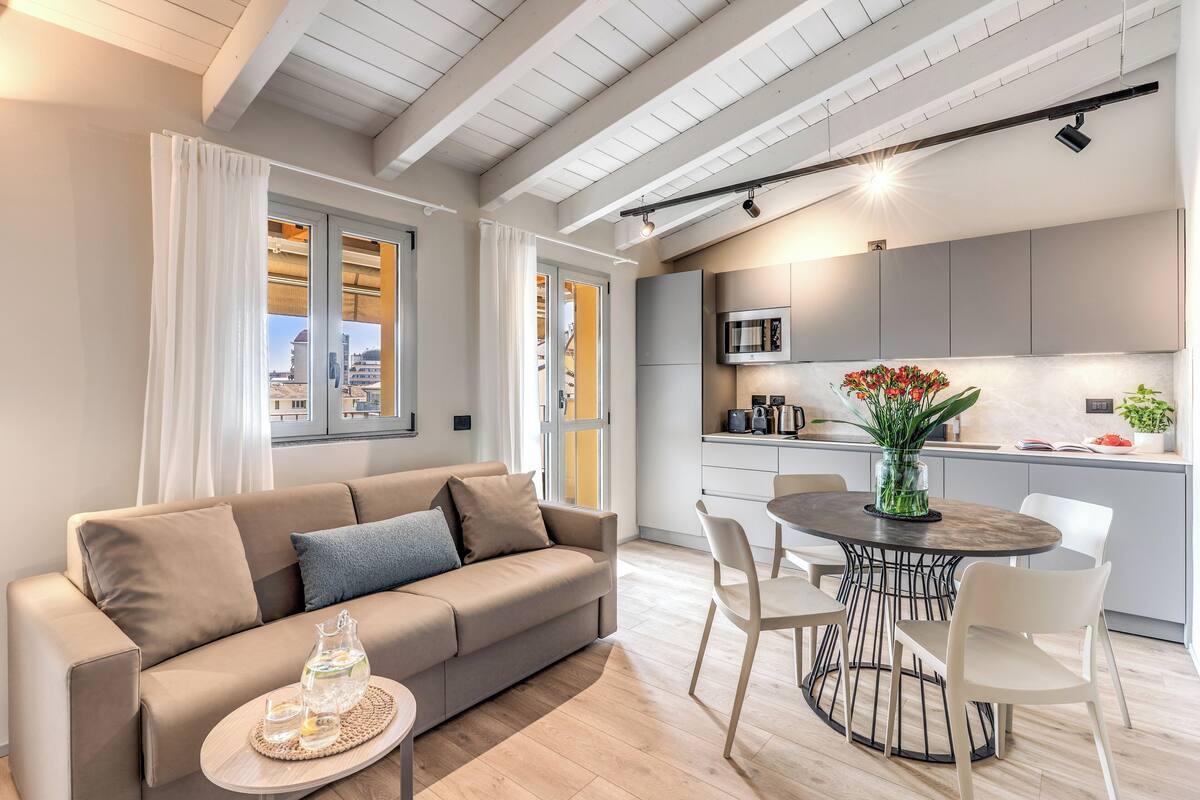 A modern living room with a sofa, coffee table, and dining area.