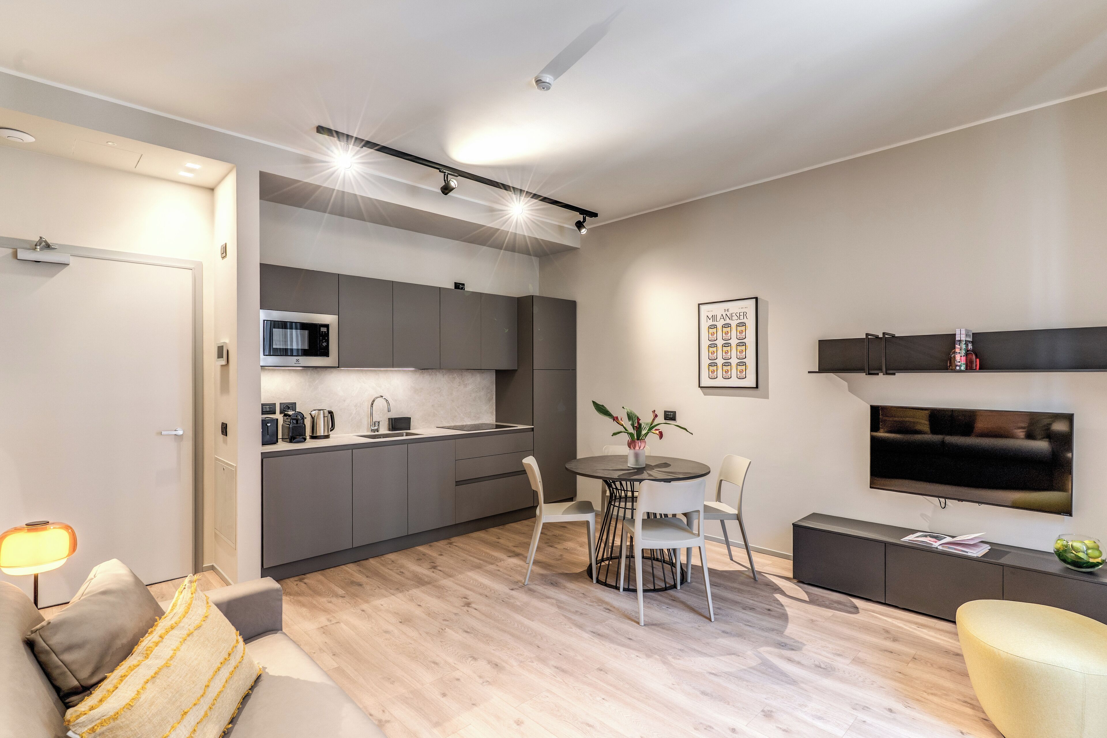 A modern living space with a kitchen, dining area, and seating area.
