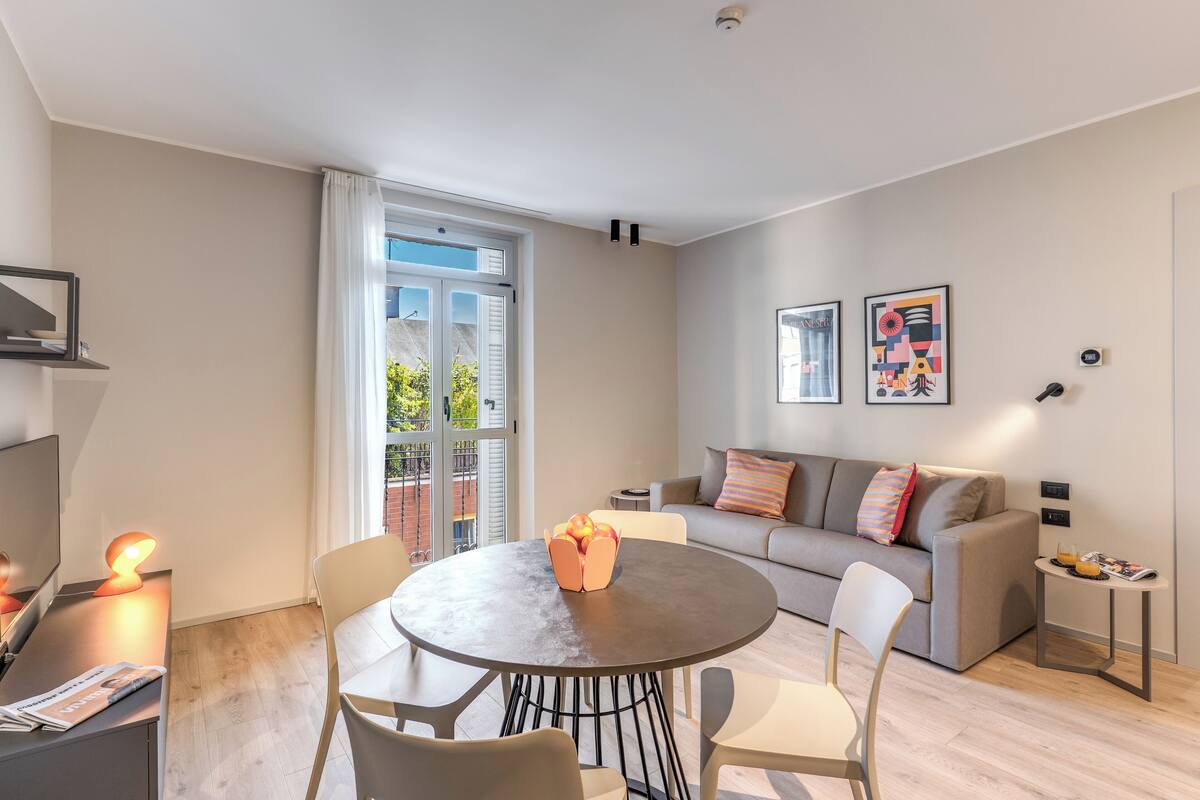 A modern living room with a round table, a sofa, and a TV.