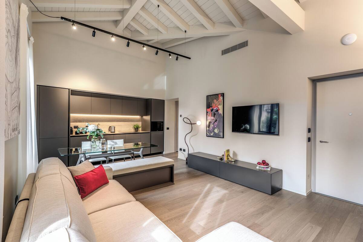 Una sala de estar moderna con un sofá, una mesa de comedor y una cocina al fondo.