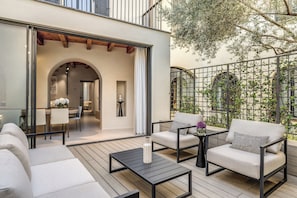 An outdoor patio with a sofa, two armchairs, a coffee table, and a dining area. - Seety Porta Romana Statue (Milan)