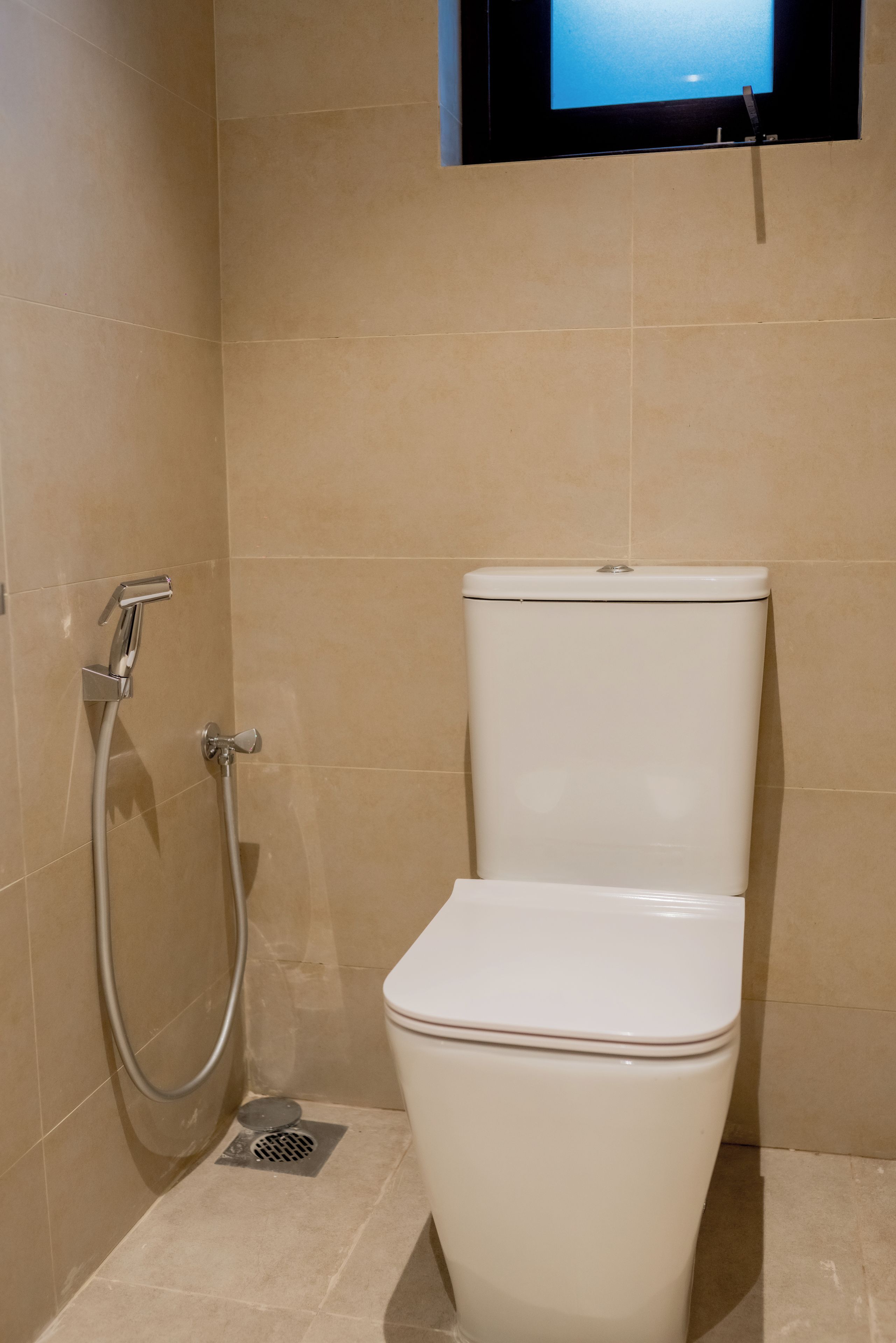 Une salle de bain équipée de toilettes, d’une douche et d’un téléviseur fixé au mur.