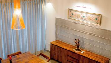 A dining area with a wooden table, chairs, a bench, and a hanging light fixture.
