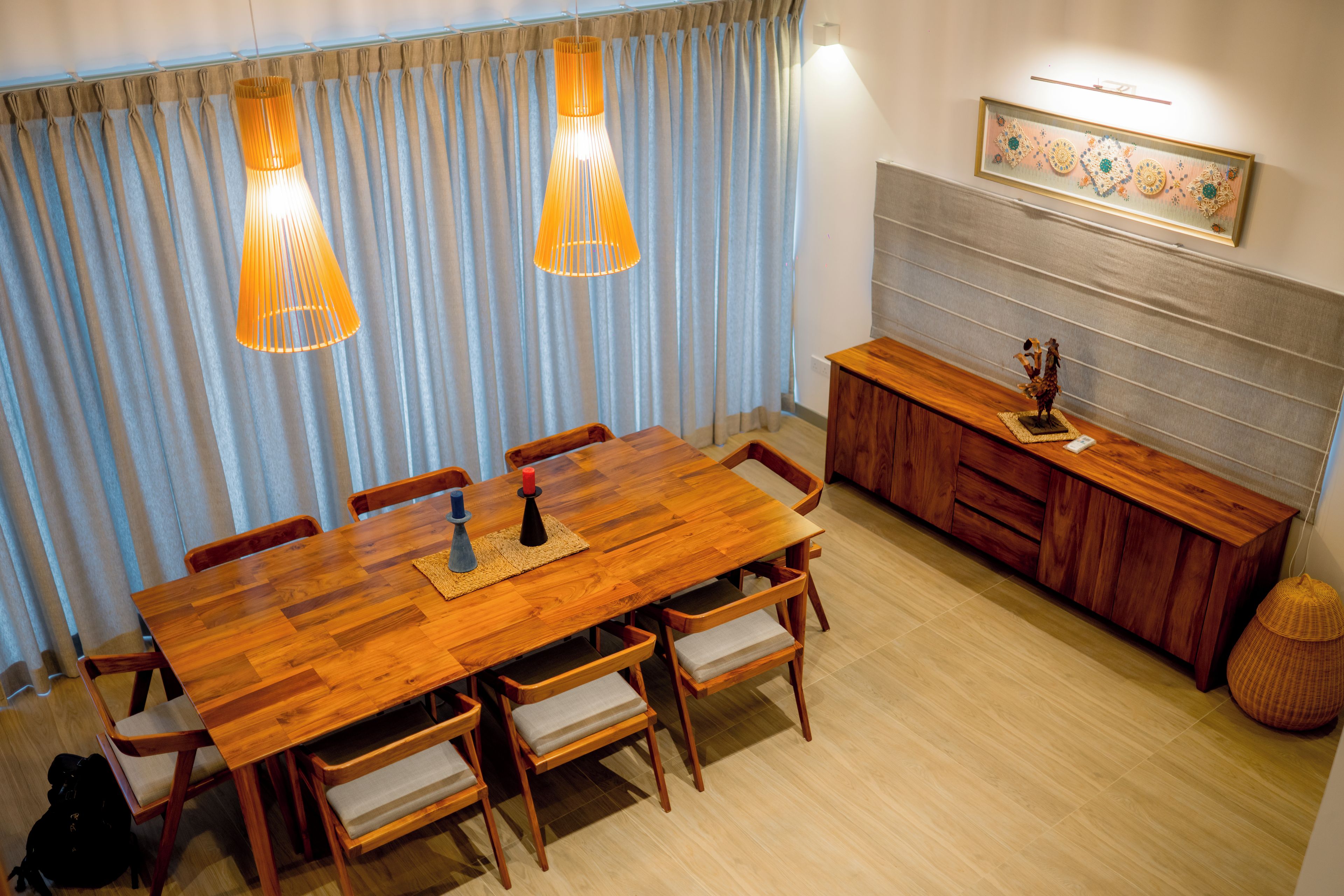 Een eetgedeelte met een houten tafel, stoelen en een buffet.