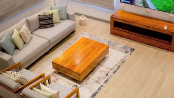 Una sala de estar moderna con sofá, mesa de centro y televisor.
