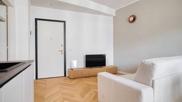 Apartament, 3 dormitoris, balcó | Sala d'estar | Televisor intel·ligent de 32 polzades amb canals per cable