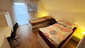 Un dormitorio con cama, escritorio y silla.