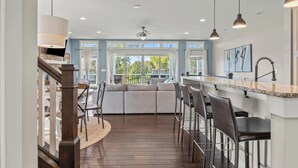 Een moderne keuken met een bar, grote ramen en uitzicht op de omgeving.