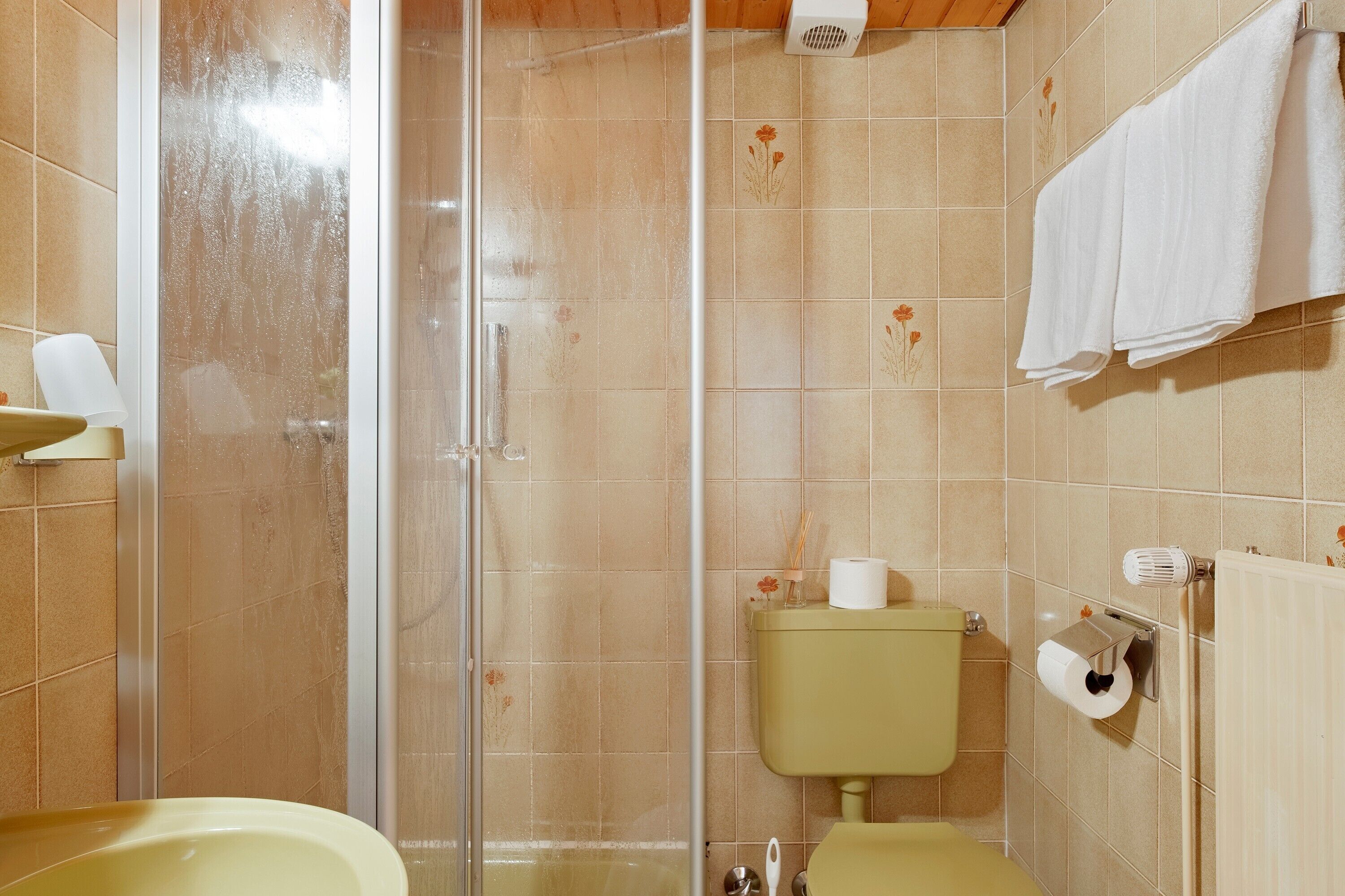 A bathroom with a shower, toilet, and sink.