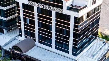 Un hotel moderno con un letrero llamativo, varios pisos y un techo plano.