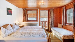 Habitación tipo cabaña de madera con dos camas, un radiador y una ventana con cortinas.