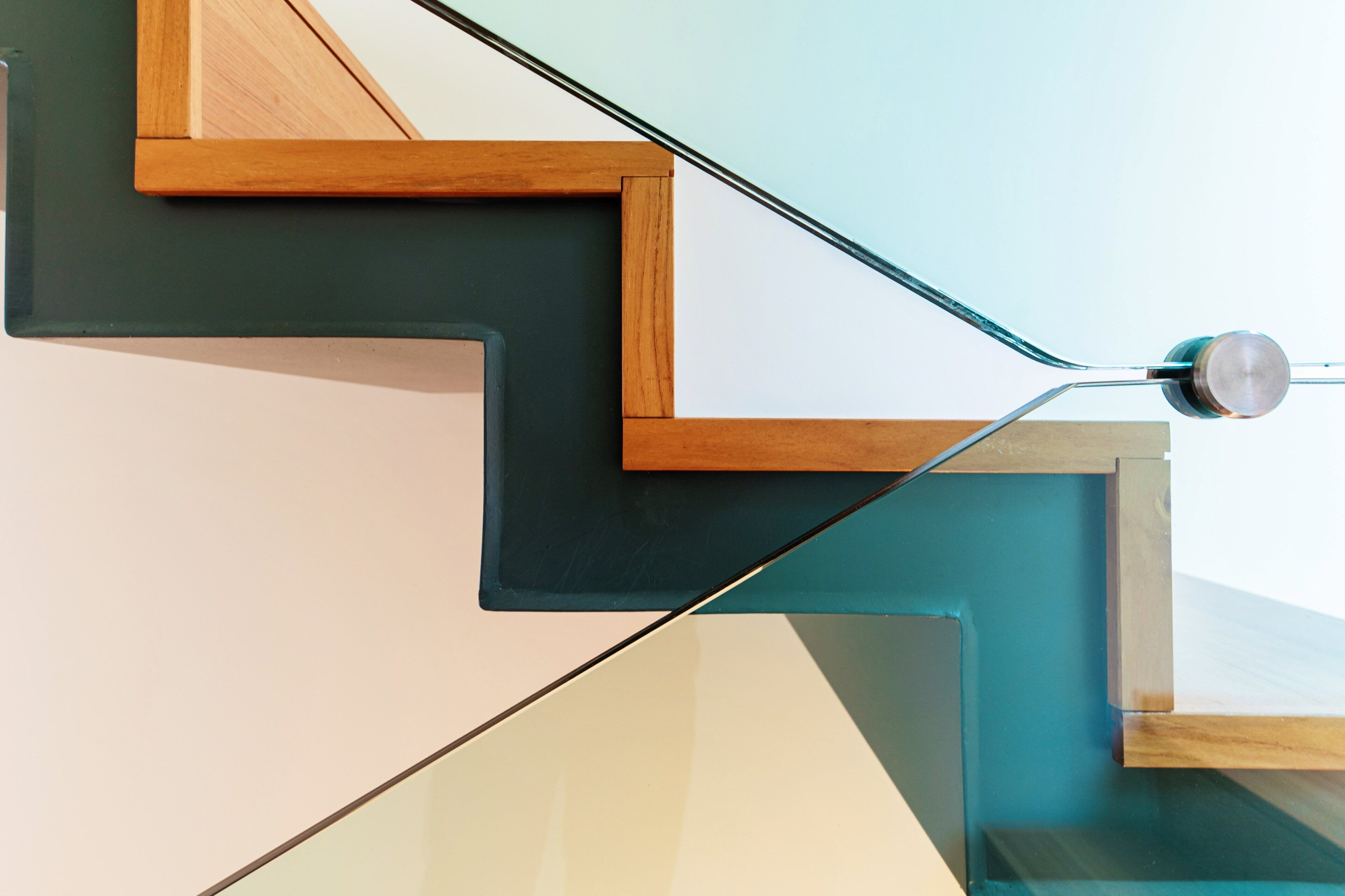 Una escalera moderna con diseños geométricos y barandilla de vidrio.