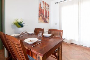 Ein Esstisch, gedeckt mit Tellern, Gläsern und einer Blumenvase.