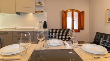 A dining area with a table set for four, a coffee maker, and a microwave on the counter.