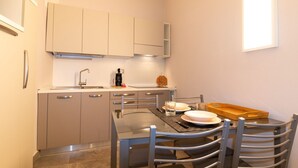 Una cocina compacta con una mesa de comedor, sillas y un horno empotrado.