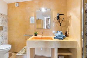 A bathroom with a beige sink, a mirror, a hairdryer, and a towel rack. - Bosa Eye House 1873 | Castle (Bosa)