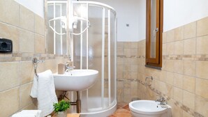 A bathroom with a shower, sink, bidet, and a mirror. - Domo Mea Rooms- Camera 2 (CABRAS)