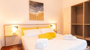 A hotel room with a bed, two bedside lamps, a painting, a wardrobe, and neatly folded towels. -  Domo Mea Rooms- Camera 4 (CABRAS)