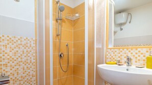 A bathroom with a shower, sink, and tiled walls. -  Domo Mea Rooms- Camera 4 (CABRAS)