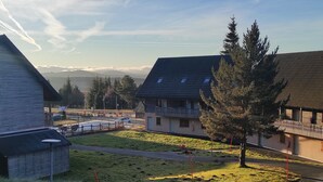 A residential area with houses, a grassy field, and a road. - Apartment 5 Pers. with Pool in Super-Besse (Besse-et-Saint-Anastaise-Super Besse)