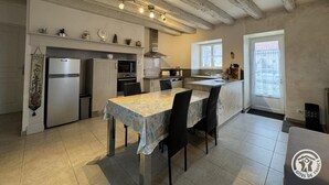 Une cuisine équipée d’une table à manger, de chaises, d’un réfrigérateur, d’un four, d’un four à micro-ondes et d’une fenêtre.