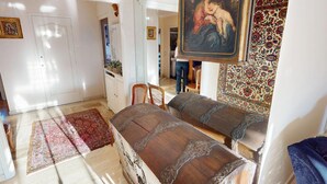 A room with a large bed, a painting, a patterned rug, and a white door. - Pleasant 3P in Menton with terrace and garage (Menton)
