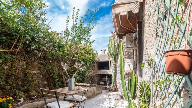 A courtyard with a table and chairs, a potted plant, and a cactus. - In Barberia- Cozy Corner (Milis)