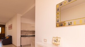 Une cuisine moderne avec des meubles blancs, un plan de travail blanc et un miroir décoratif orné de motifs animaliers.