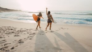 Two people walking on a sandy beach with ocean waves in the background. - Mobile home 26m² with terrace in Soustons, nature camping (Soustons)