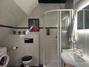 Een haardroger, handdoeken, zeep, toiletpapier