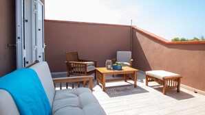A balcony with a sofa, two chairs, a table, and a bench. - Casa Tatti- Calm&Natural (San Giovanni di Sinis)