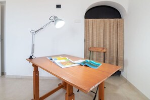 Un bureau en bois, une lampe, une chaise et des magazines ouverts.