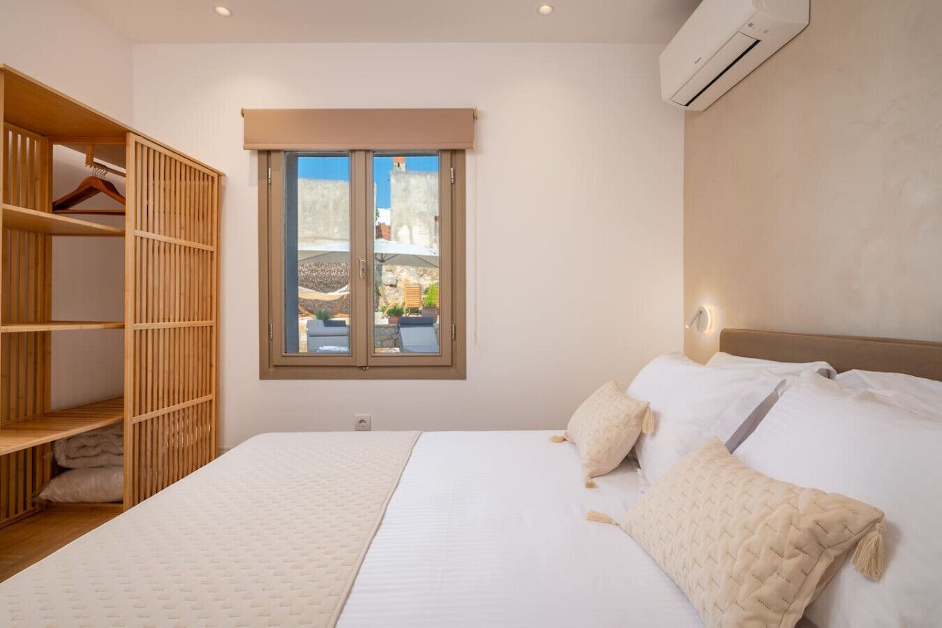 Une chambre à coucher comprenant un lit, une armoire, une fenêtre avec vue et un appareil de climatisation.