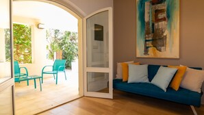 An open living area with a sofa, chairs, and a painting on the wall.