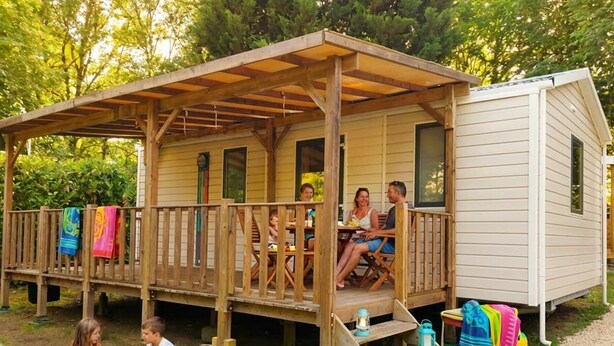 A wooden deck with a covered porch, a grill, and a children's play area. - Mobile home 27m² in Saint-Gérons with terrace (Saint-Gérons)