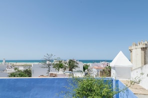 Eine Küstenlandschaft mit klarem Himmel, einem Strand in der Ferne und einem markanten weißen Turm.